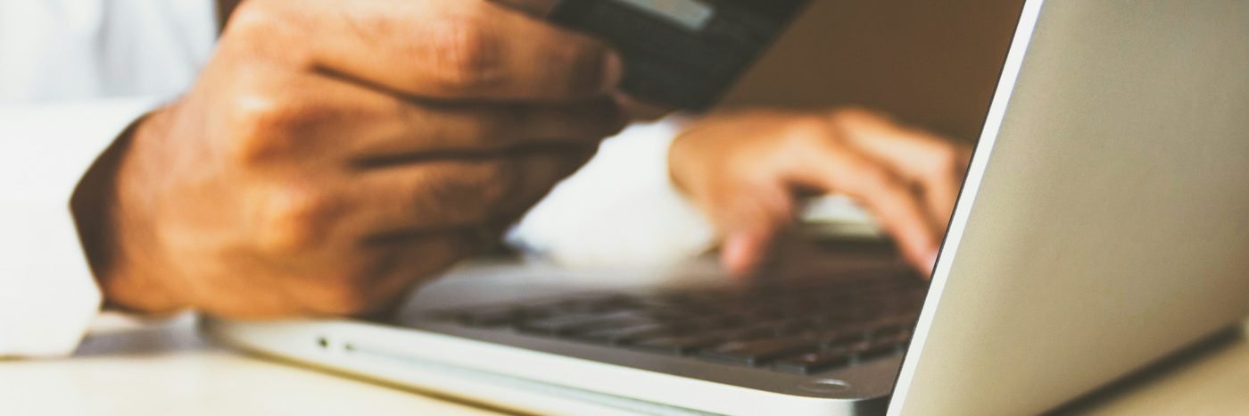 Online betaling met een bankpas achter een laptop